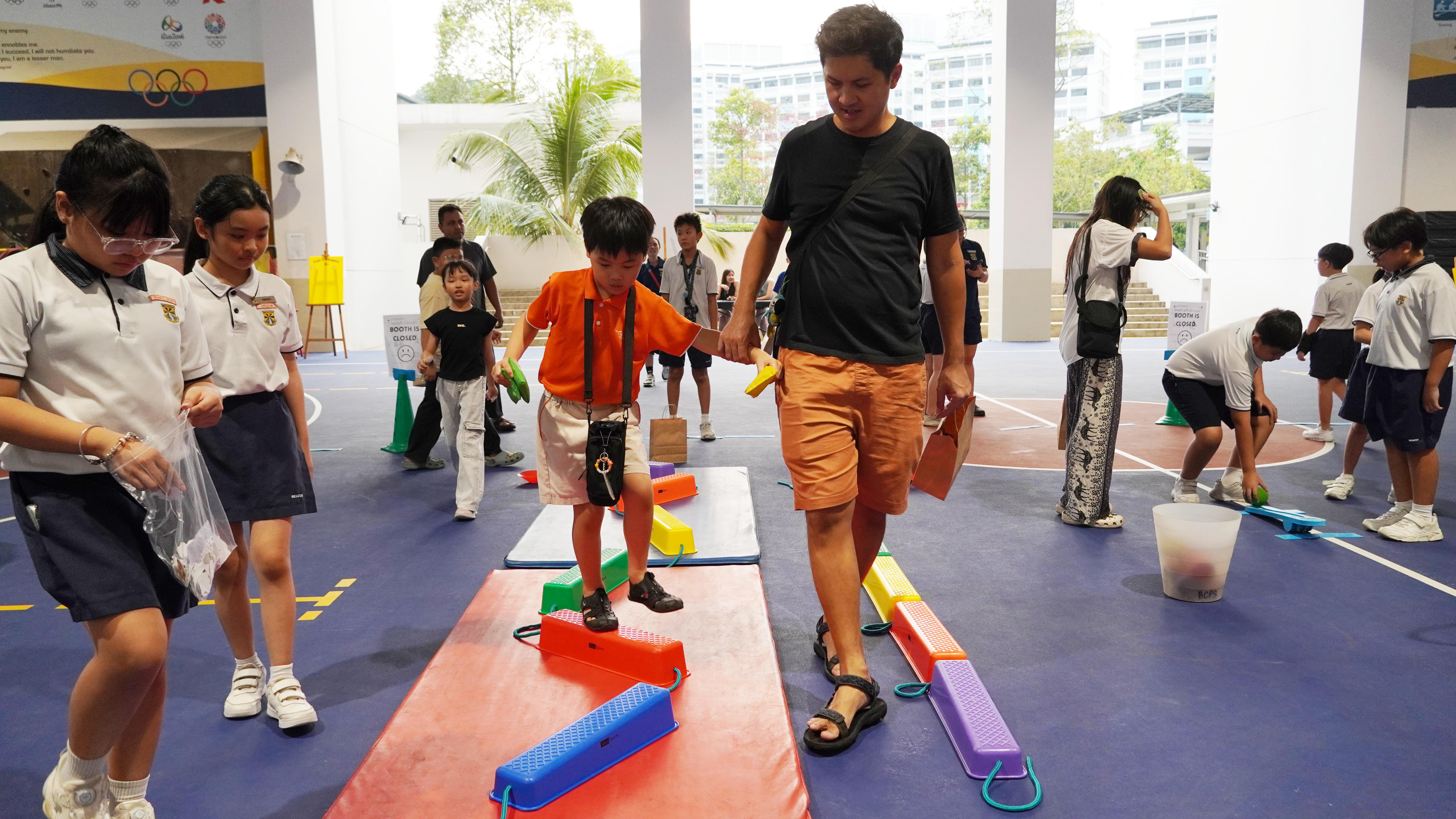 Steady does it! A young participant carefully makes his way across the colourful balance beams.